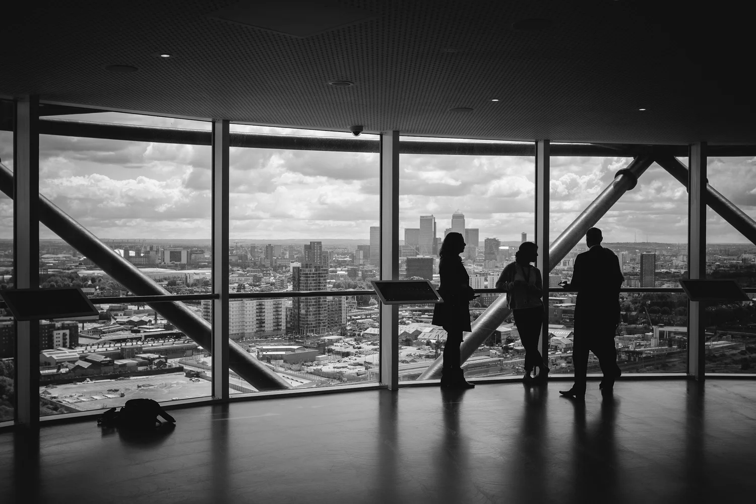 Business professionals in silhouette overlooking a city skyline from a high-rise office — representing strategic advisory